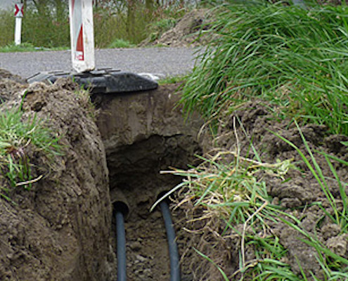Buis met raketboor onder de weg door trekken